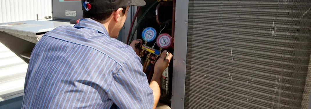 HVAC technician servicing a condenser unit in Bartow