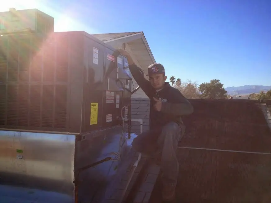 HVAC technician performing Heat Pump Repair on a rooftop unit in Bartow